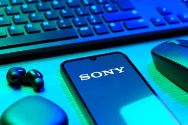 Prag, Çek Cumhuriyeti - 08 12 2025: Sony logosunu gösteren klavyesi ve cep telefonu olan bir masanın yan görüntüsü. Sony elektronik, oyun ve eğlence üreten bir teknoloji şirketidir..