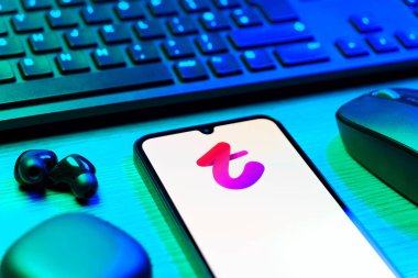 Prag, Çek Cumhuriyeti - 08 12 2025: Tango logosunu gösteren klavyesi ve cep telefonu olan bir masanın yan görüntüsü. Tango, görüntülü aramalar, mesajlar ve canlı yayınlar için sosyal bir uygulama..