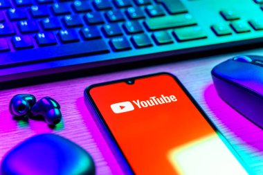 Prague, Czechia - 08 12 2025: A side view of a desk with a keyboard and a mobile phone displaying the Youtube logo. Youtube is a platform to watch and share videos worldwide.