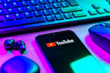 Prague, Czechia - 08 12 2025: A side view of a desk with a keyboard and a mobile phone displaying the Youtube logo. Youtube is a platform to watch and share videos worldwide.