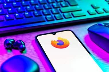 Prag, Çek Cumhuriyeti - 08 12 2025: Firefox logosunu gösteren klavyesi ve cep telefonu olan bir masanın yan görüntüsü. Firefox hızlı ve güvenli internet taraması için bir web tarayıcısıdır.