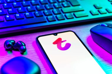 Prag, Çek Cumhuriyeti - 08 12 2025: Tango logosunu gösteren klavyesi ve cep telefonu olan bir masanın yan görüntüsü. Tango, görüntülü aramalar, mesajlar ve canlı yayınlar için sosyal bir uygulama..