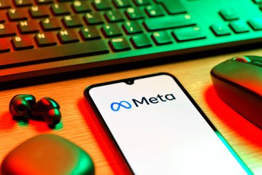 Prague, Czechia - 08 12 2025: A side view of a desk with a keyboard and a mobile phone displaying the Meta logo. Meta is a company offering social platforms like Facebook and Instagram.