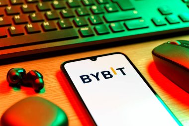 Prague, Czechia - 08 12 2025: A side view of a desk with a keyboard and a mobile phone displaying the Bybit logo. Bybit is a platform for trading cryptocurrencies and derivatives.