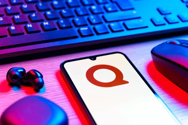 Prag, Çek Cumhuriyeti - 08 12 2025: Quora logosunu gösteren klavyesi ve cep telefonu olan bir masanın yan görüntüsü. Quora soru sormak ve bilgi paylaşmak için bir platformdur..