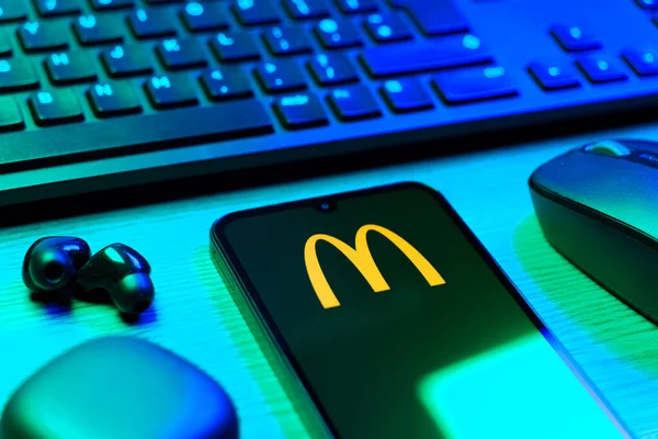 Prag, Çek Cumhuriyeti - 08 12 2025: McDonalds logosunu gösteren klavyesi ve cep telefonu olan bir masanın yan görüntüsü. McDonalds hamburger, patates kızartması ve daha fazlası sunan bir fast-food zinciri..