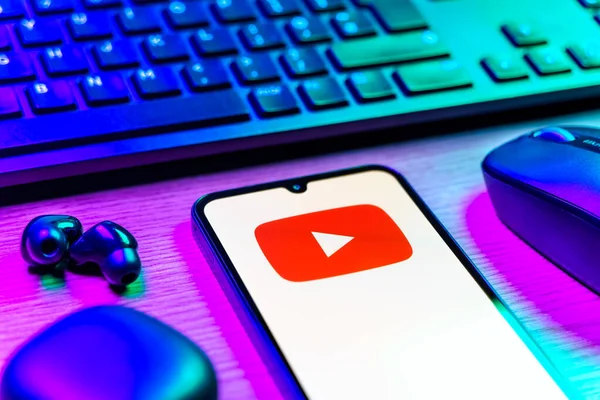 Prague, Czechia - 08 12 2025: A side view of a desk with a keyboard and a mobile phone displaying the Youtube logo. Youtube is a platform to watch and share videos worldwide.