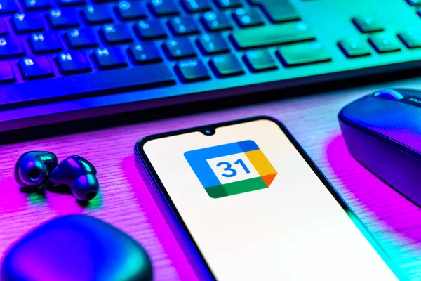 Prag, Çek Cumhuriyeti - 08 12 2025: Google Takvim logosunu gösteren klavyesi ve cep telefonu olan bir masanın yan görüntüsü. Google Takvimi olayları zamanlamak ve yönetmek için bir platformdur.