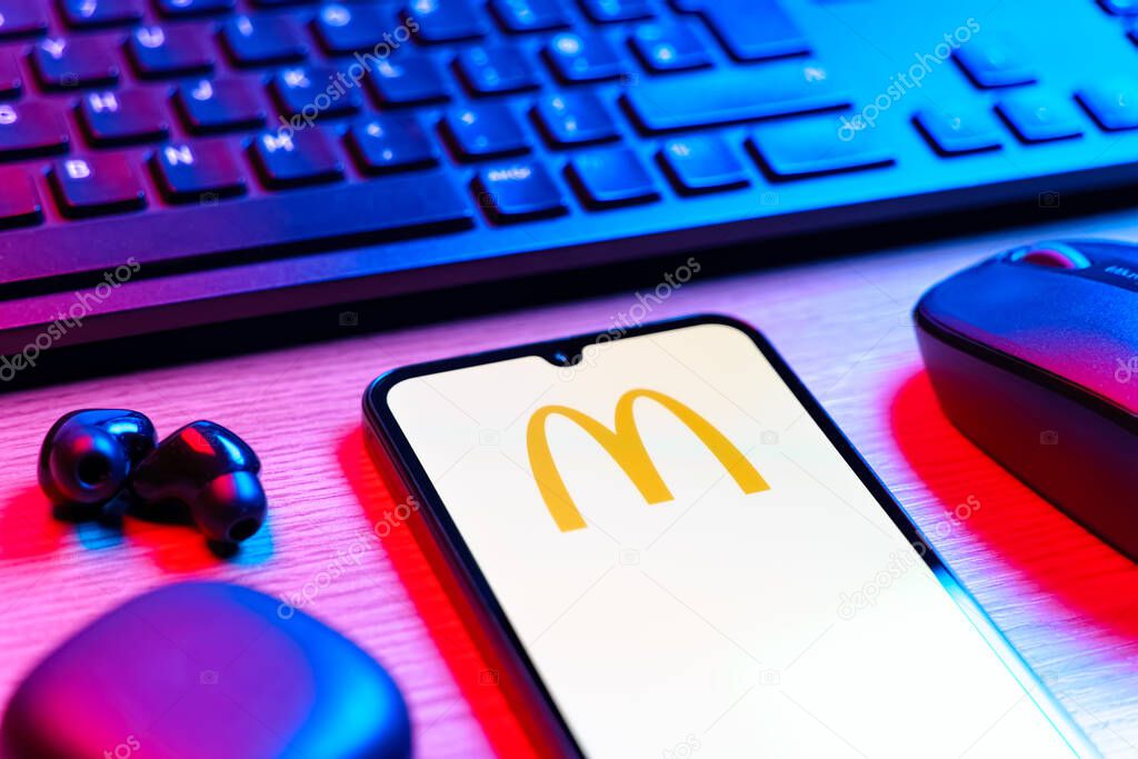 Prague, Czechia - 08 12 2025: A side view of a desk with a keyboard and a mobile phone displaying the McDonalds logo. McDonalds is a fast-food chain serving burgers, fries, and more.