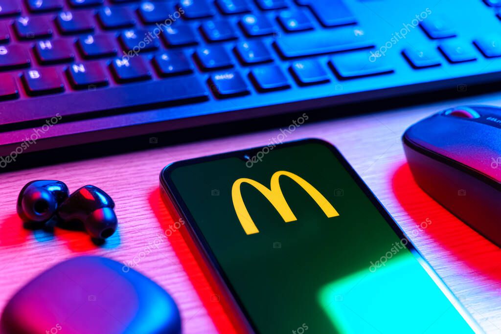 Prague, Czechia - 08 12 2025: A side view of a desk with a keyboard and a mobile phone displaying the McDonalds logo. McDonalds is a fast-food chain serving burgers, fries, and more.
