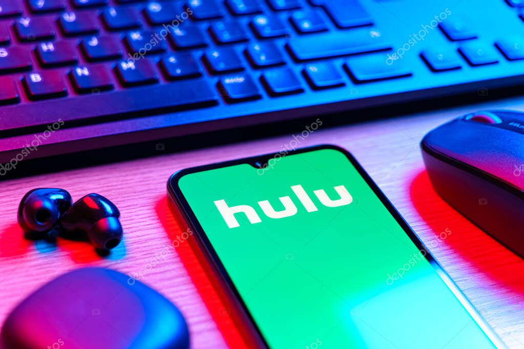 Prague, Czechia - 08 12 2025: A side view of a desk with a keyboard and a mobile phone displaying the Hulu logo. Hulu is a streaming platform for TV shows, movies, and live TV.