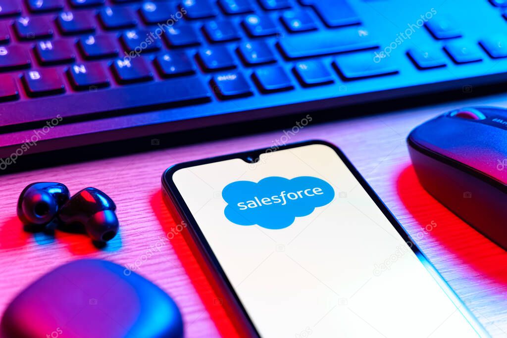 Prague, Czechia - 08 12 2025: A side view of a desk with a keyboard and a mobile phone displaying the Salesforce logo. Salesforce is a platform for customer relationship management and cloud services.