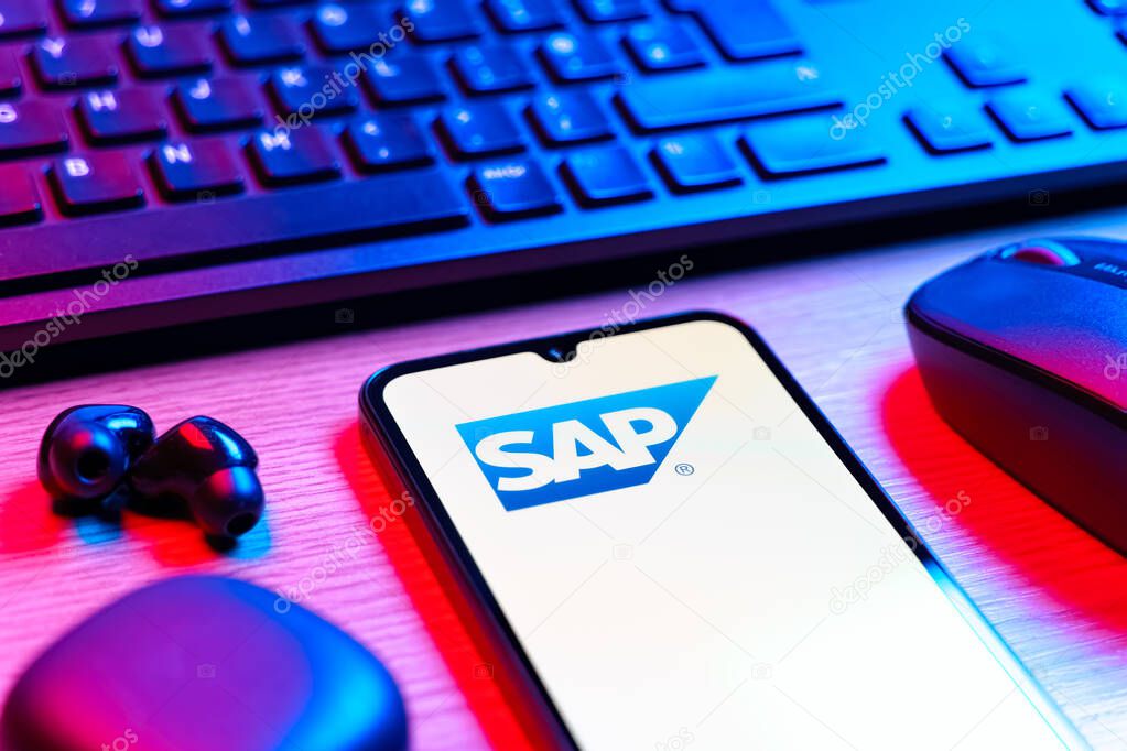 Prague, Czechia - 08 12 2025: A side view of a desk with a keyboard and a mobile phone displaying the SAP logo. SAP is a software company providing enterprise applications and solutions.