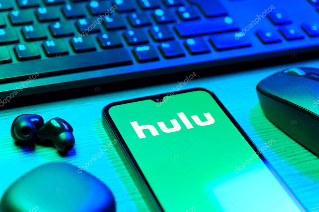 Prague, Czechia - 08 12 2025: A side view of a desk with a keyboard and a mobile phone displaying the Hulu logo. Hulu is a streaming platform for TV shows, movies, and live TV.