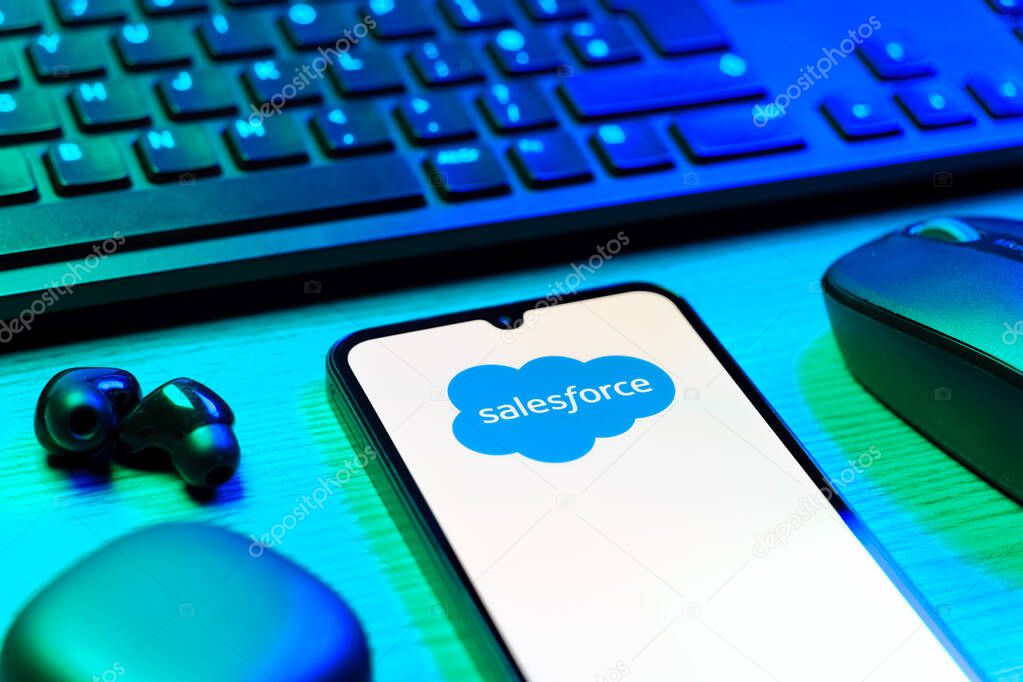 Prague, Czechia - 08 12 2025: A side view of a desk with a keyboard and a mobile phone displaying the Salesforce logo. Salesforce is a platform for customer relationship management and cloud services.