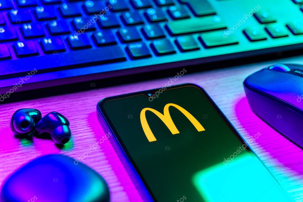 Prague, Czechia - 08 12 2025: A side view of a desk with a keyboard and a mobile phone displaying the McDonalds logo. McDonalds is a fast-food chain serving burgers, fries, and more.