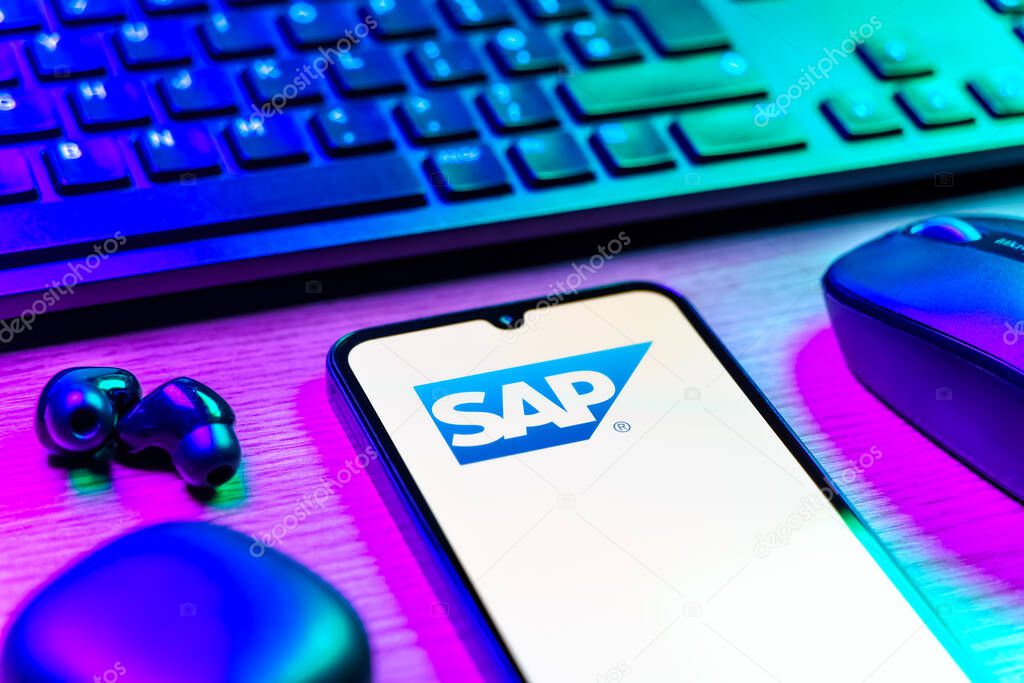 Prague, Czechia - 08 12 2025: A side view of a desk with a keyboard and a mobile phone displaying the SAP logo. SAP is a software company providing enterprise applications and solutions.