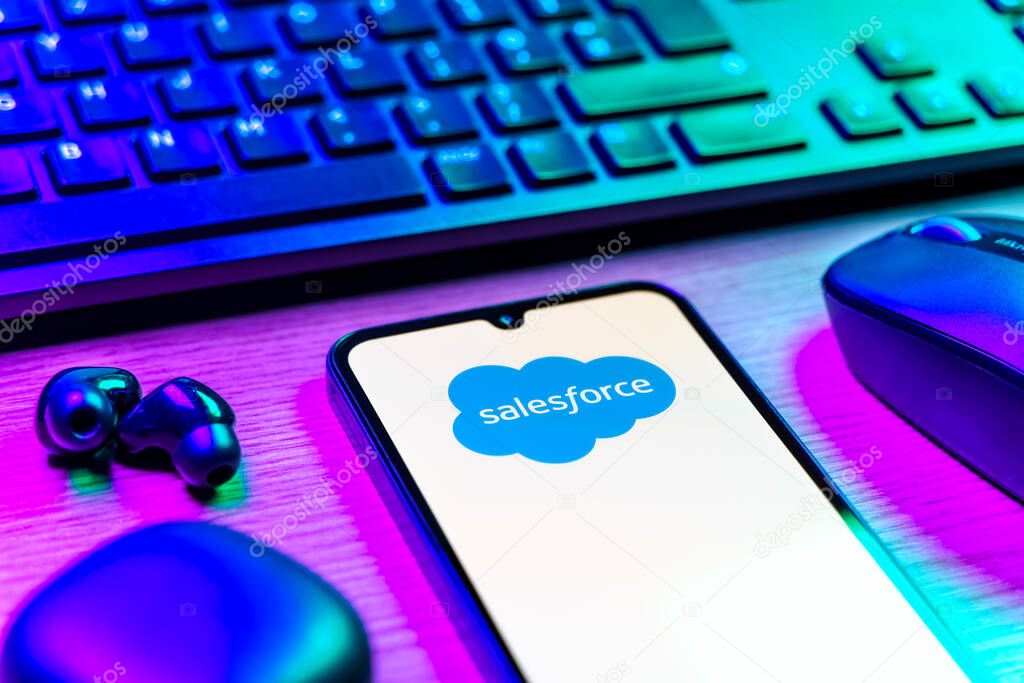 Prague, Czechia - 08 12 2025: A side view of a desk with a keyboard and a mobile phone displaying the Salesforce logo. Salesforce is a platform for customer relationship management and cloud services.