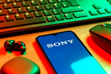 Prag, Çek Cumhuriyeti - 08 12 2025: Sony logosunu gösteren klavyesi ve cep telefonu olan bir masanın yan görüntüsü. Sony elektronik, oyun ve eğlence üreten bir teknoloji şirketidir..
