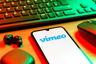 Prag, Çek Cumhuriyeti - 08 12 2025: Vimeo logosunu gösteren klavyesi ve cep telefonu olan bir masanın yan görüntüsü. Vimeo, yüksek kaliteli video sunucu ve paylaşımı için bir platformdur.