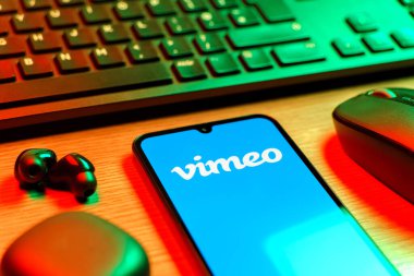 Prag, Çek Cumhuriyeti - 08 12 2025: Vimeo logosunu gösteren klavyesi ve cep telefonu olan bir masanın yan görüntüsü. Vimeo, yüksek kaliteli video sunucu ve paylaşımı için bir platformdur.