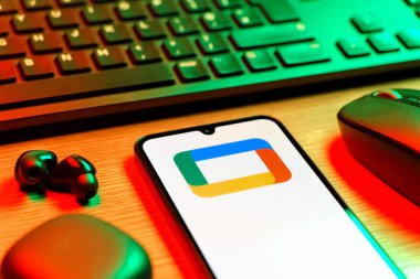 Prag, Çek Cumhuriyeti - 08 12 2025: Google TV logosunu gösteren klavyesi ve cep telefonu olan bir masanın yan görüntüsü. Google TV film, program ve uygulamalar için bir platformdur..