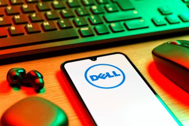 Prag, Çek Cumhuriyeti - 08 12 2025: Dell logosunu gösteren klavyesi ve cep telefonu olan bir masanın yan görüntüsü. Dell bilgisayar ve bilişim çözümleri üreten bir teknoloji şirketidir..