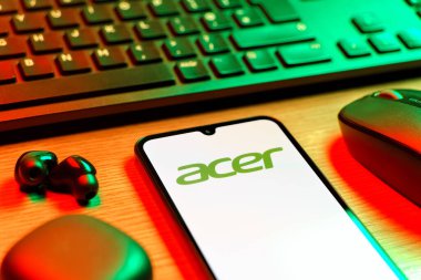 Prag, Çek Cumhuriyeti - 08 12 2025: Acer logosunu gösteren klavyesi ve cep telefonu olan bir masanın yan görüntüsü. Acer bilgisayar ve elektronik üreten bir teknoloji şirketidir..