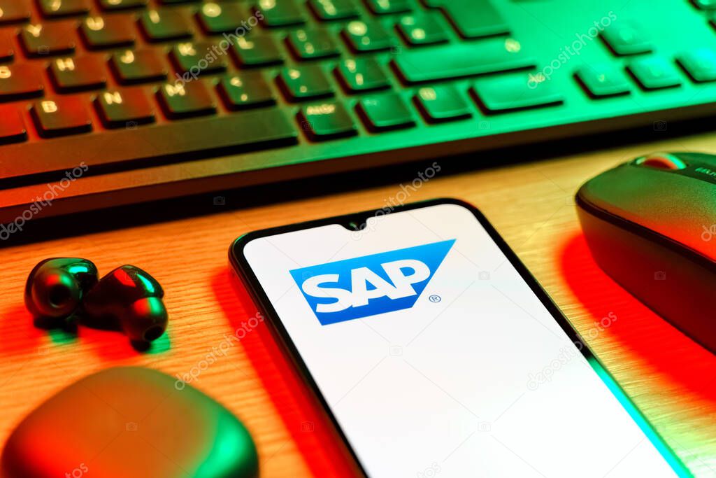 Prague, Czechia - 08 12 2025: A side view of a desk with a keyboard and a mobile phone displaying the SAP logo. SAP is a software company providing enterprise applications and solutions.