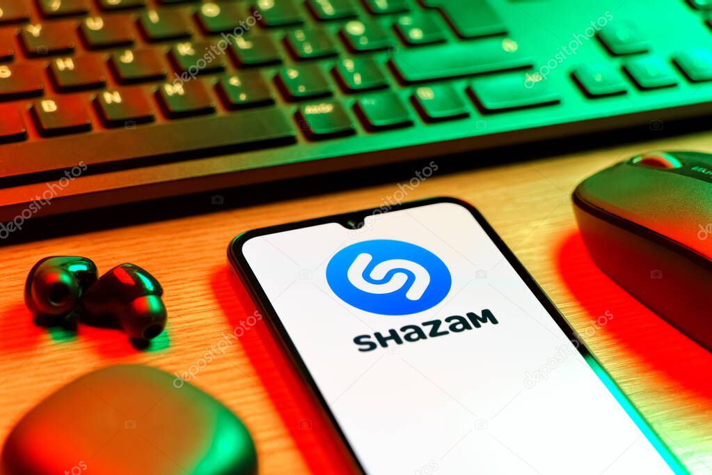 Prague, Czechia - 08 12 2025: A side view of a desk with a keyboard and a mobile phone displaying the Shazam logo. Shazam is an app for identifying songs and music tracks.