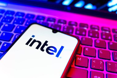 Prag, Çek Cumhuriyeti - 08 19 2025: Intel logosunu gösteren klavyenin üzerinde duran bir cep telefonunun yakından görüntüsü. Intel işlemci ve bilgisayar donanımı üreten bir teknoloji şirketidir..