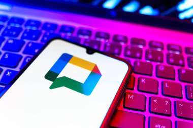 Prag, Çek Cumhuriyeti - 08 19 2025: Google Chat logosunu gösteren klavyenin üzerinde duran cep telefonunun yakından görüntüsü. Google Chat mesajlaşma ve takım işbirliği için bir platformdur.