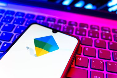 Prag, Çek Cumhuriyeti - 08 19 2025: Google Family Link logosunu gösteren klavyenin üzerinde duran cep telefonunun yakından görüntüsü. Google Family Link ebeveyn denetimi ve çocuk hesabı yönetimi için bir platformdur.