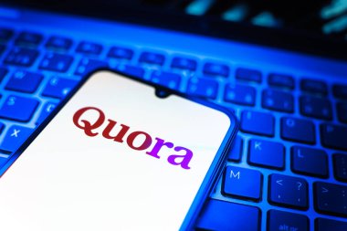 Prag, Çek Cumhuriyeti - 08 19 2025: Klavyede duran ve Quora logosunu gösteren cep telefonunun yakından görüntüsü. Quora soru sormak ve bilgi paylaşmak için bir platformdur..