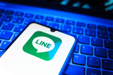 Prag, Çek Cumhuriyeti - 08 19 2025: Bir cep telefonunun klavyede duran ve hat logosunu gösteren yakın plan görüntüsü. Line aramalar, mesajlar ve çokluortam paylaşımı için bir mesajlaşma uygulamasıdır.