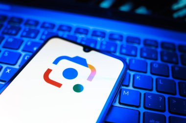 Prag, Çek Cumhuriyeti - 08 19 2025: Google Lens logosunu gösteren klavyenin üzerinde duran cep telefonunun yakından görüntüsü. Google Lens, resimlerdeki görsel arama ve bilgi için kullanılan bir araçtır..