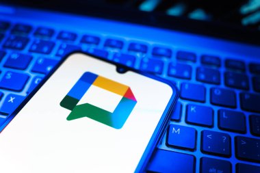Prag, Çek Cumhuriyeti - 08 19 2025: Google Chat logosunu gösteren klavyenin üzerinde duran cep telefonunun yakından görüntüsü. Google Chat mesajlaşma ve takım işbirliği için bir platformdur.