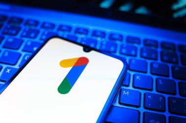 Prag, Çek Cumhuriyeti - 08 19 2025: Bir klavyenin üzerinde duran ve Google One logosunu gösteren cep telefonunun yakından görüntüsü. Google 1 bulut depolama ve abonelik hizmetleri için bir platformdur.
