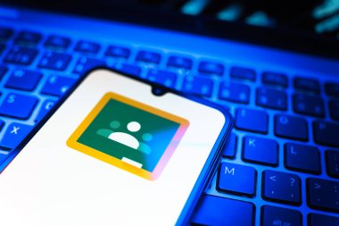 Prag, Çek Cumhuriyeti - 08 19 2025: Google Sınıfı logosunu gösteren klavyenin üzerinde duran cep telefonunun yakından görüntüsü. Google Sınıfı, sınıfları ve eğitim içeriğini yönetmek için bir platformdur.