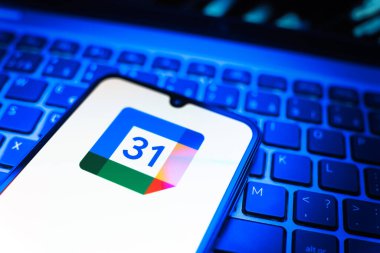 Prag, Çek Cumhuriyeti - 08 19 2025: Google Takvim logosunu gösteren klavyenin üzerinde duran cep telefonunun yakından görüntüsü. Google Takvimi olayları zamanlamak ve yönetmek için bir platformdur.