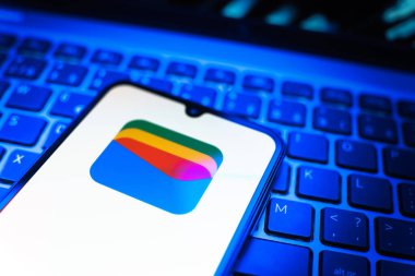 Prag, Çek Cumhuriyeti - 08 19 2025: Google Cüzdan logosunu gösteren klavyenin üzerinde duran cep telefonunun yakından görüntüsü. Google Cüzdanı dijital ödeme yöntemlerini depolamak ve kullanmak için bir platformdur.