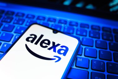 Prag, Çek Cumhuriyeti - 08 19 2025: Klavyenin üzerinde Alexa logosunu gösteren cep telefonunun yakın çekim görüntüsü. Alexa akıllı aygıtlar ve servisler için ses asistanıdır.