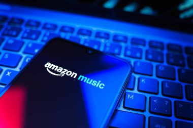 Prag, Çek Cumhuriyeti - 08 19 2025: Bir klavyenin üzerinde duran ve Amazon Müzik logosunu gösteren cep telefonunun yakından görüntüsü. Amazon Müzik müzik müzik için bir platformdur..