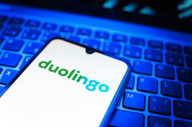 Prag, Çek Cumhuriyeti - 08 19 2025: Duolingo logosunu gösteren klavyenin üzerinde duran cep telefonunun yakından görüntüsü. Duolingo interaktif olarak dil öğrenmek için bir platformdur..