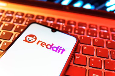 Prag, Çek Cumhuriyeti - 08 19 2025: Bir klavyenin üzerinde duran ve Reddit logosunu gösteren cep telefonunun yakından görüntüsü. Reddit tartışma, haber ve toplum içeriği için bir platformdur.