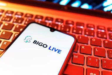 Prag, Çek Cumhuriyeti - 08 19 2025: Bigo Live logosunu gösteren klavyenin üzerinde duran cep telefonunun yakından görüntüsü. Bigo Live canlı yayın ve sosyal etkileşim için bir platformdur.
