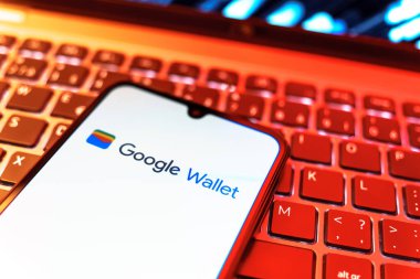 Prag, Çek Cumhuriyeti - 08 19 2025: Google Cüzdan logosunu gösteren klavyenin üzerinde duran cep telefonunun yakından görüntüsü. Google Cüzdanı dijital ödeme yöntemlerini depolamak ve kullanmak için bir platformdur.