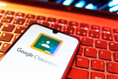 Prag, Çek Cumhuriyeti - 08 19 2025: Google Sınıfı logosunu gösteren klavyenin üzerinde duran cep telefonunun yakından görüntüsü. Google Sınıfı, sınıfları ve eğitim içeriğini yönetmek için bir platformdur.