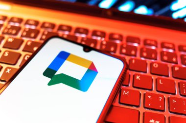 Prag, Çek Cumhuriyeti - 08 19 2025: Google Chat logosunu gösteren klavyenin üzerinde duran cep telefonunun yakından görüntüsü. Google Chat mesajlaşma ve takım işbirliği için bir platformdur.