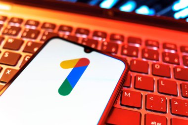 Prag, Çek Cumhuriyeti - 08 19 2025: Bir klavyenin üzerinde duran ve Google One logosunu gösteren cep telefonunun yakından görüntüsü. Google 1 bulut depolama ve abonelik hizmetleri için bir platformdur.